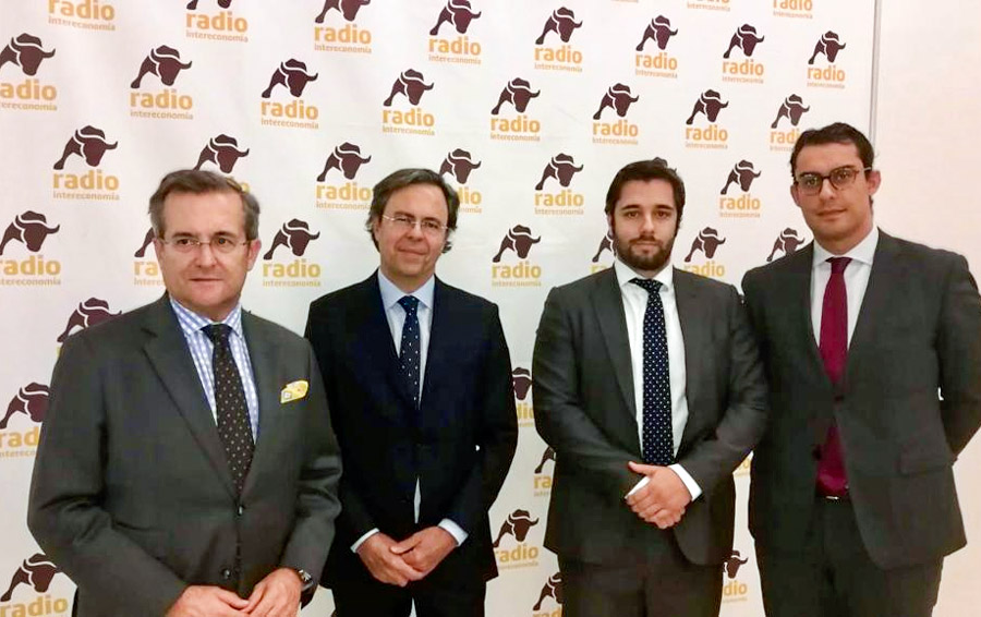 Fotografía de los miembros en la mesa de debate posando delante del logotipo de Radio Intereconomía.